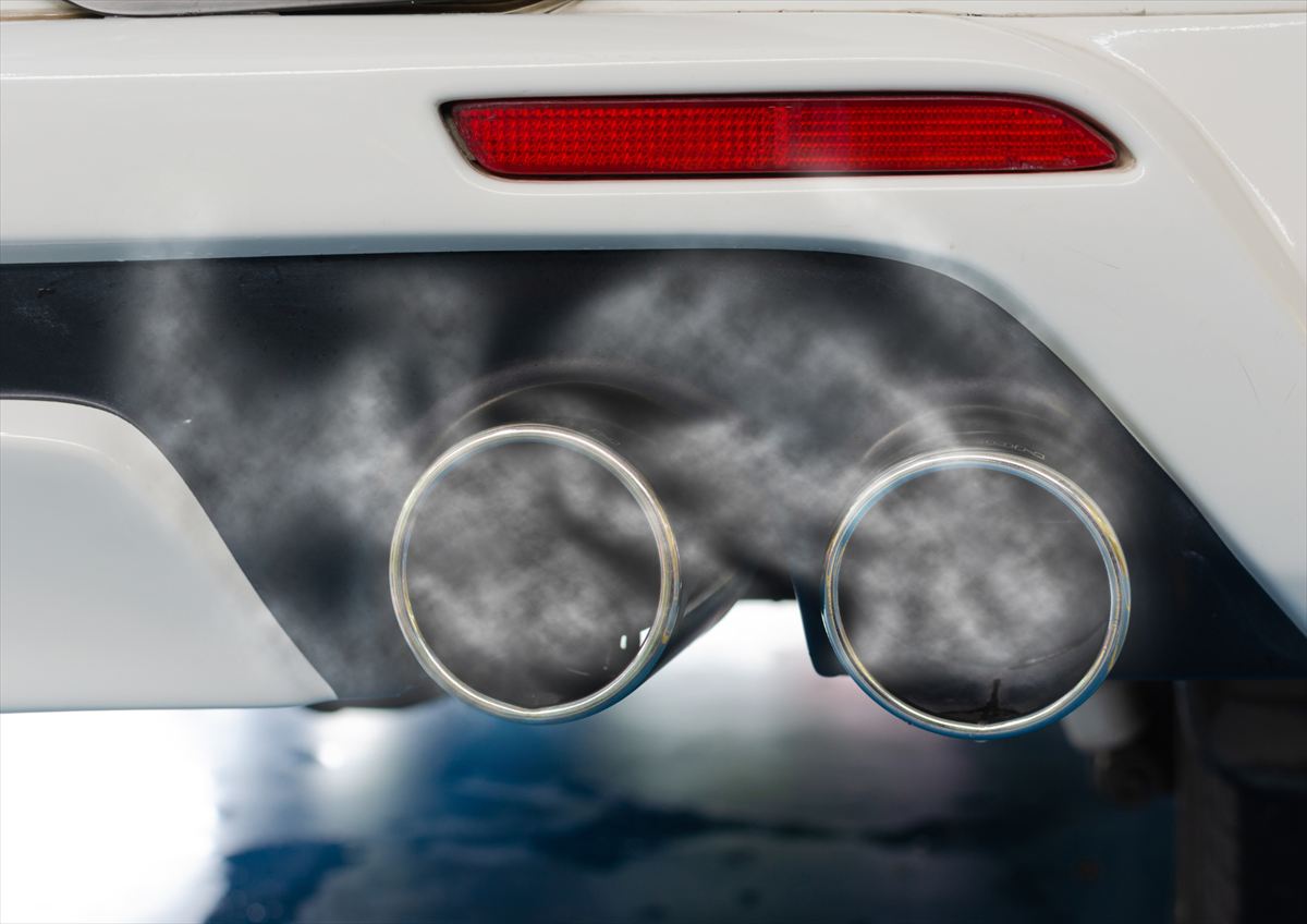 Qualmende Doppel-Endrohre am Heck eines weißen Autos
