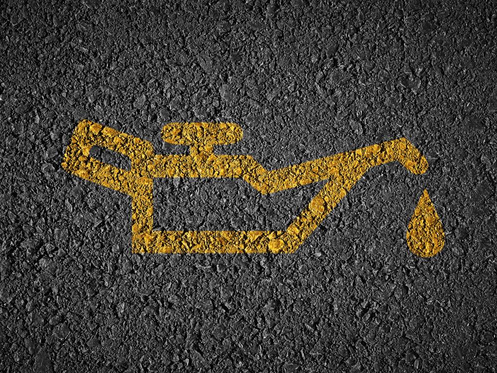 Gelbes Ölkannen-Symbol auf Asphalt